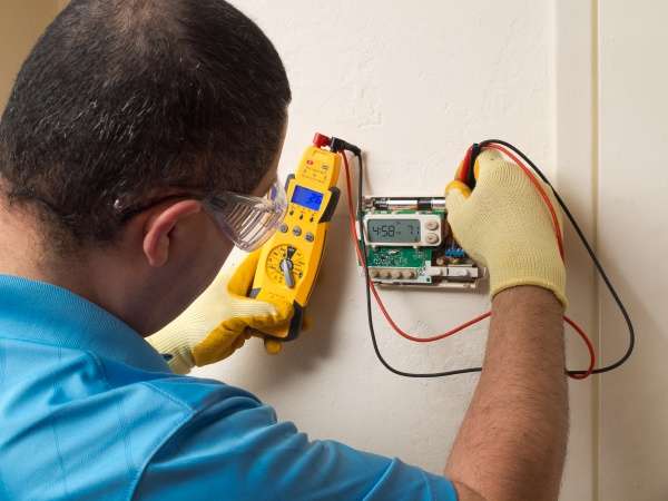 furnace repair technician in Livermore, California works on a faulty thermostat