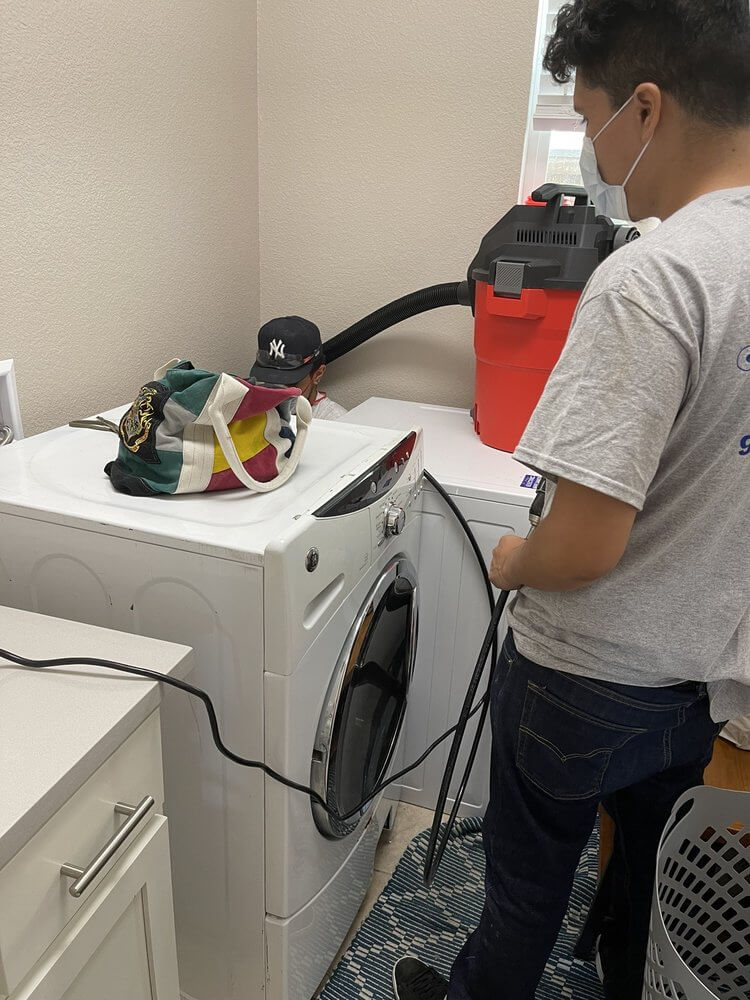 performing a dryer vent cleaning service with a vacuum